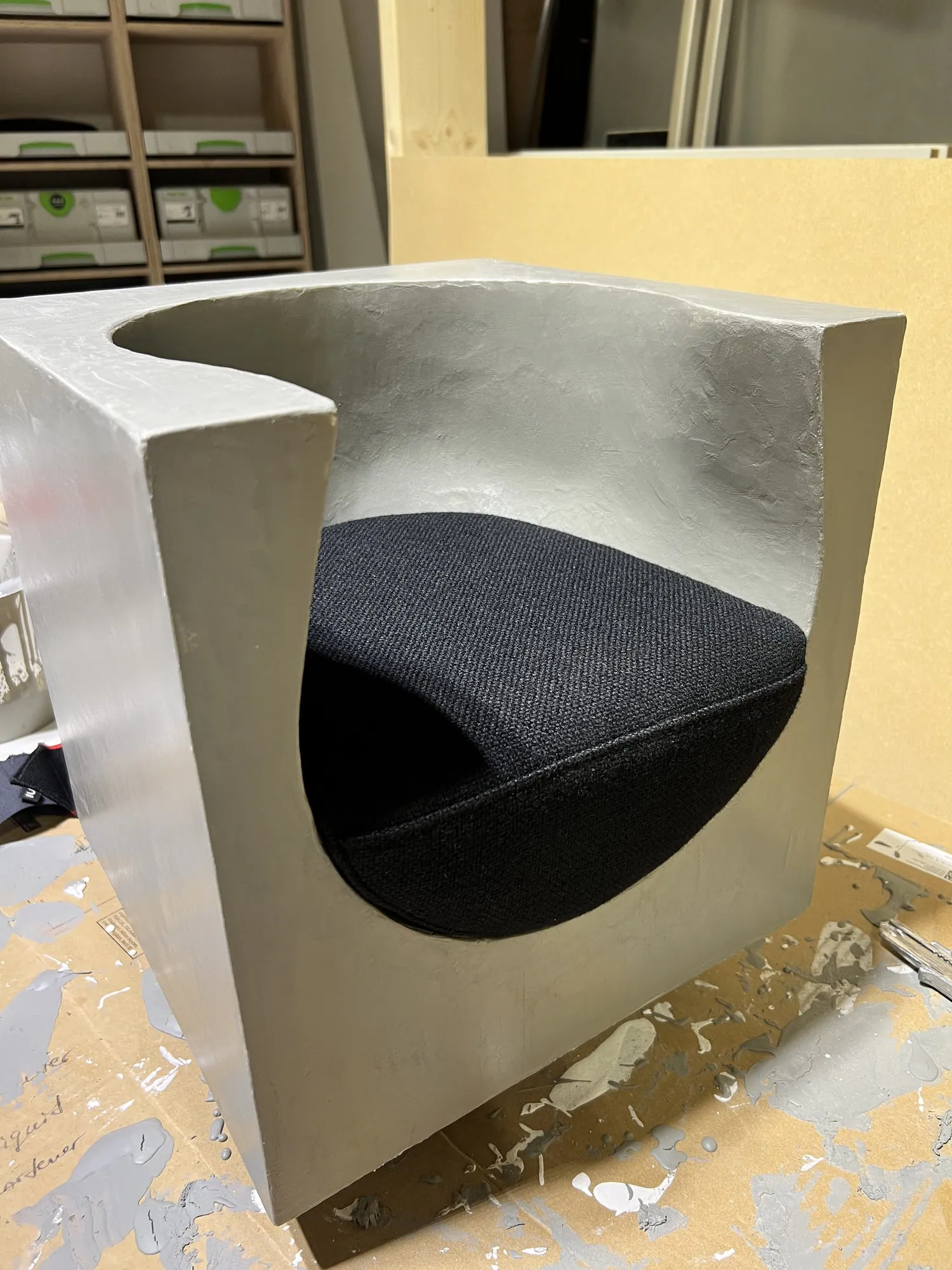 Qbé I: de grijze schaalstudie in Acero-microcement met zwart Kvadrat Hallingdal 65-kussen