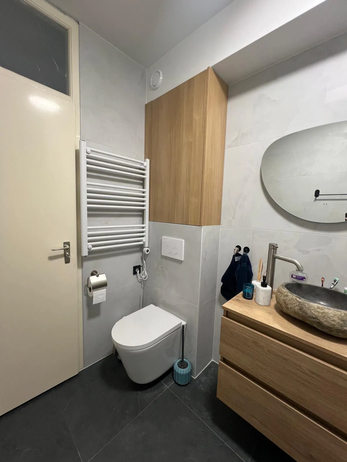 De toiletzijde met hangend toilet en handdoekradiator