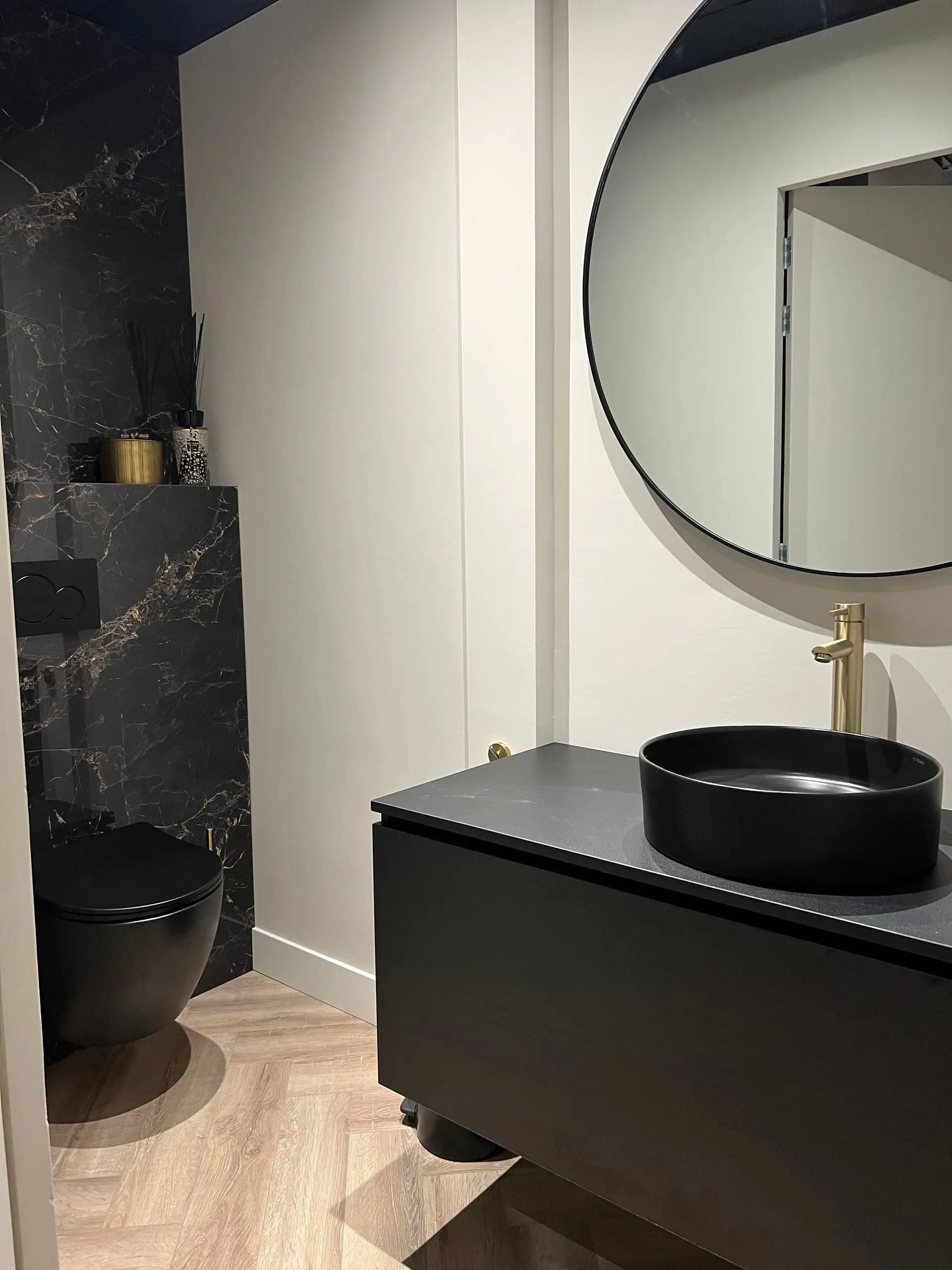 Het luxe toilet in zwart marmer met messing kraan