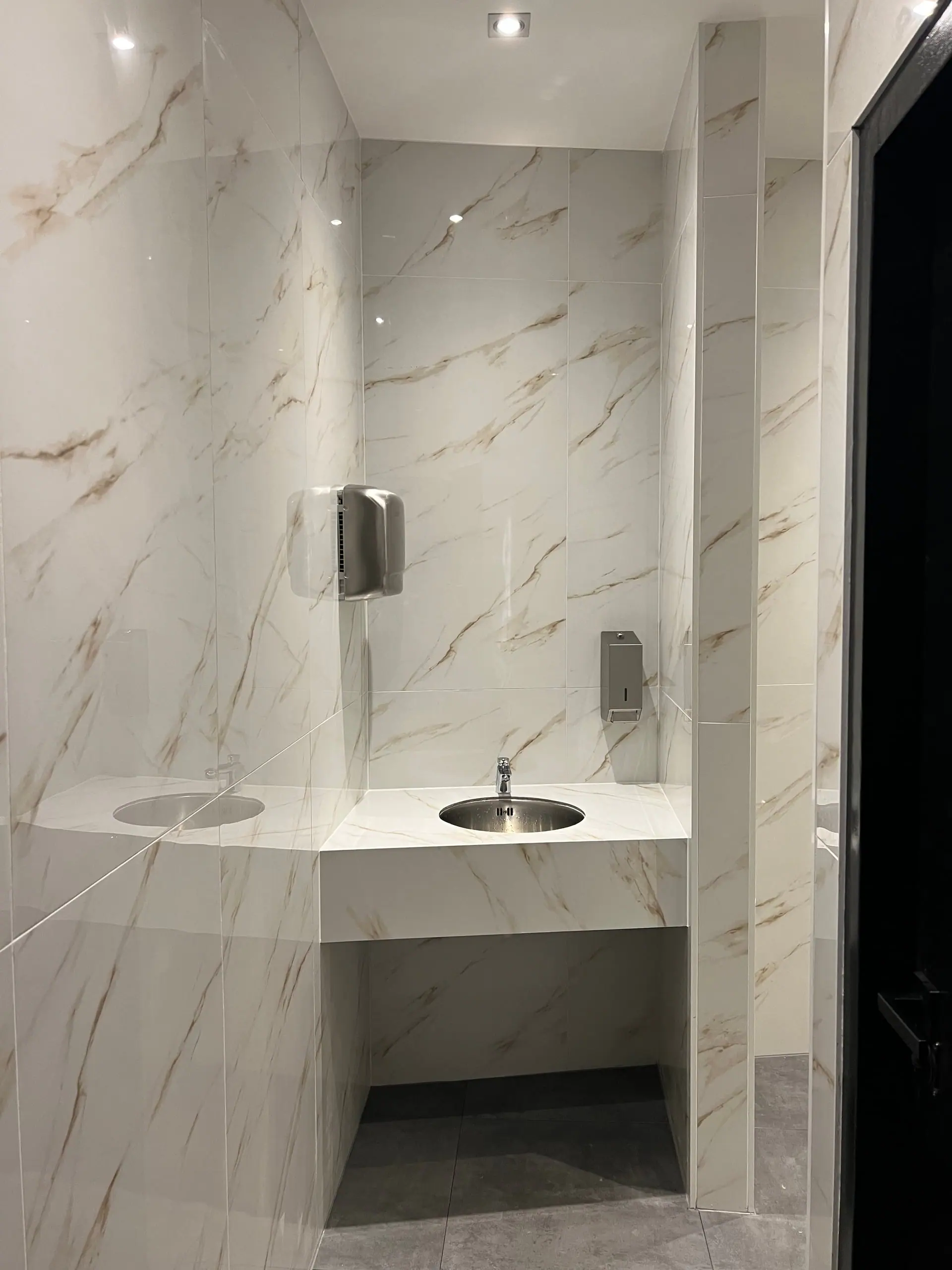 Toiletruimte van Restaria De Hoek in marmerlook porselein met zwart plafond