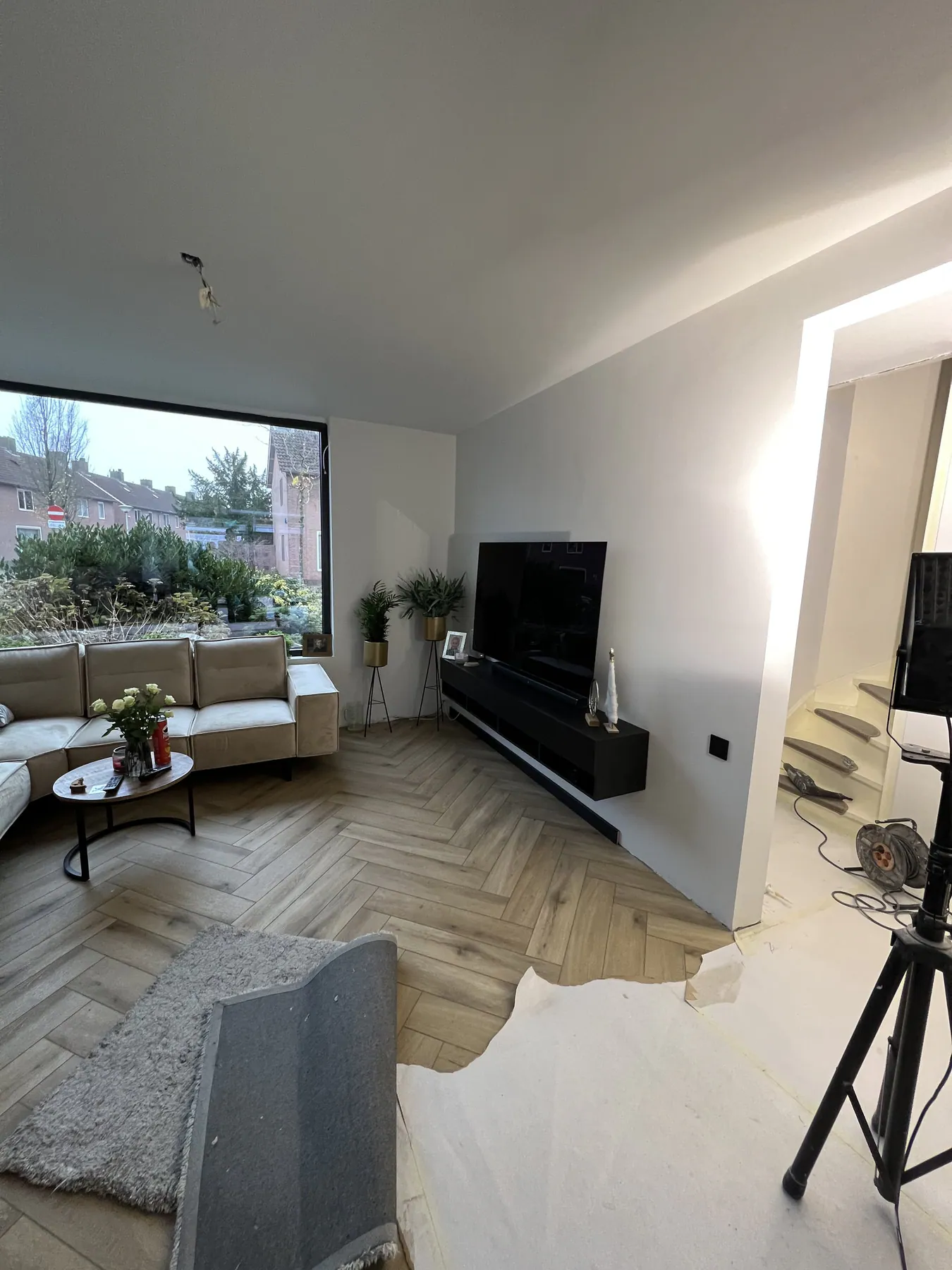 De nieuwe woonkamer met visgraatvloer en groot raam