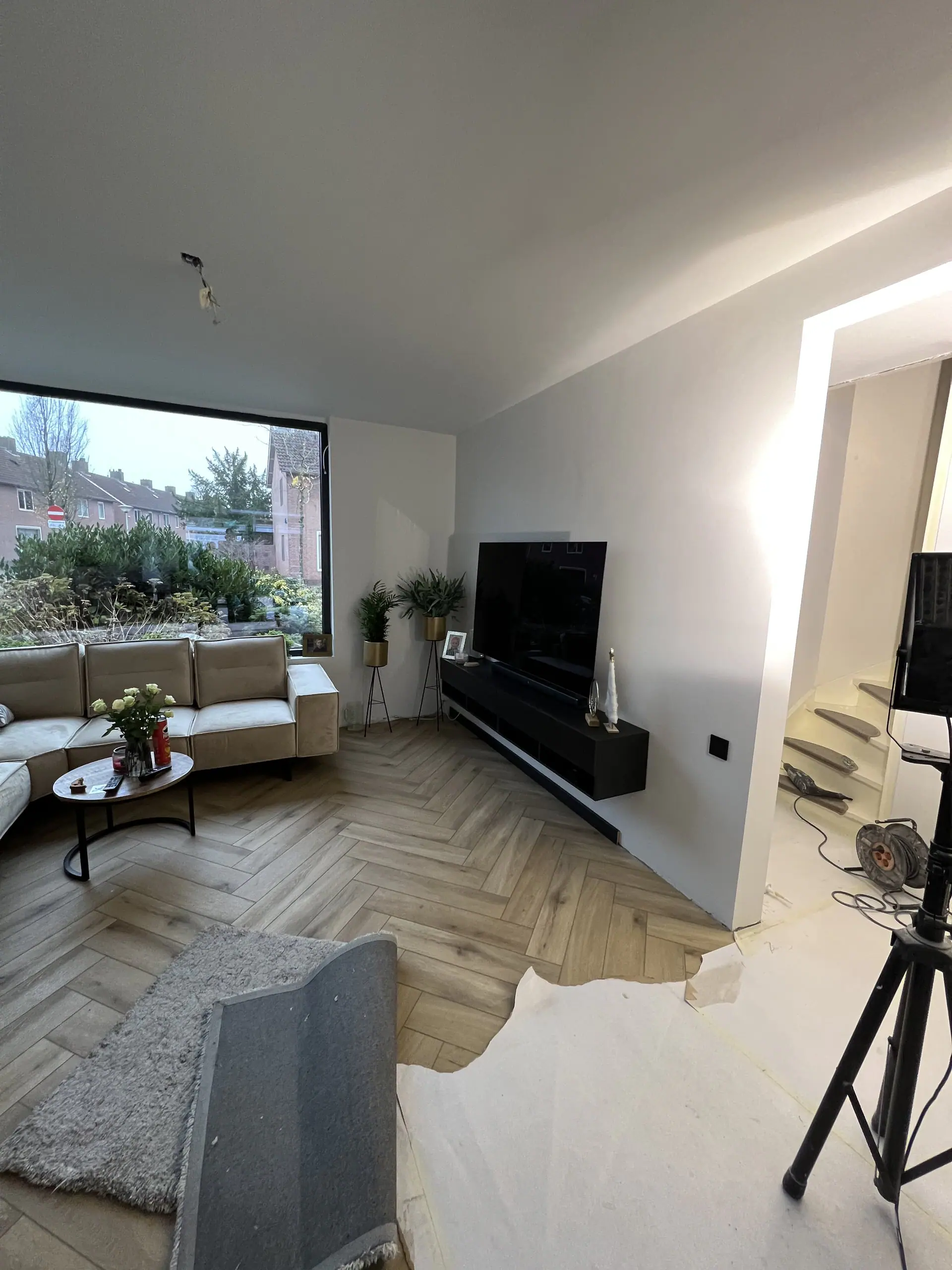 De nieuwe woonkamer met visgraatvloer en groot raam