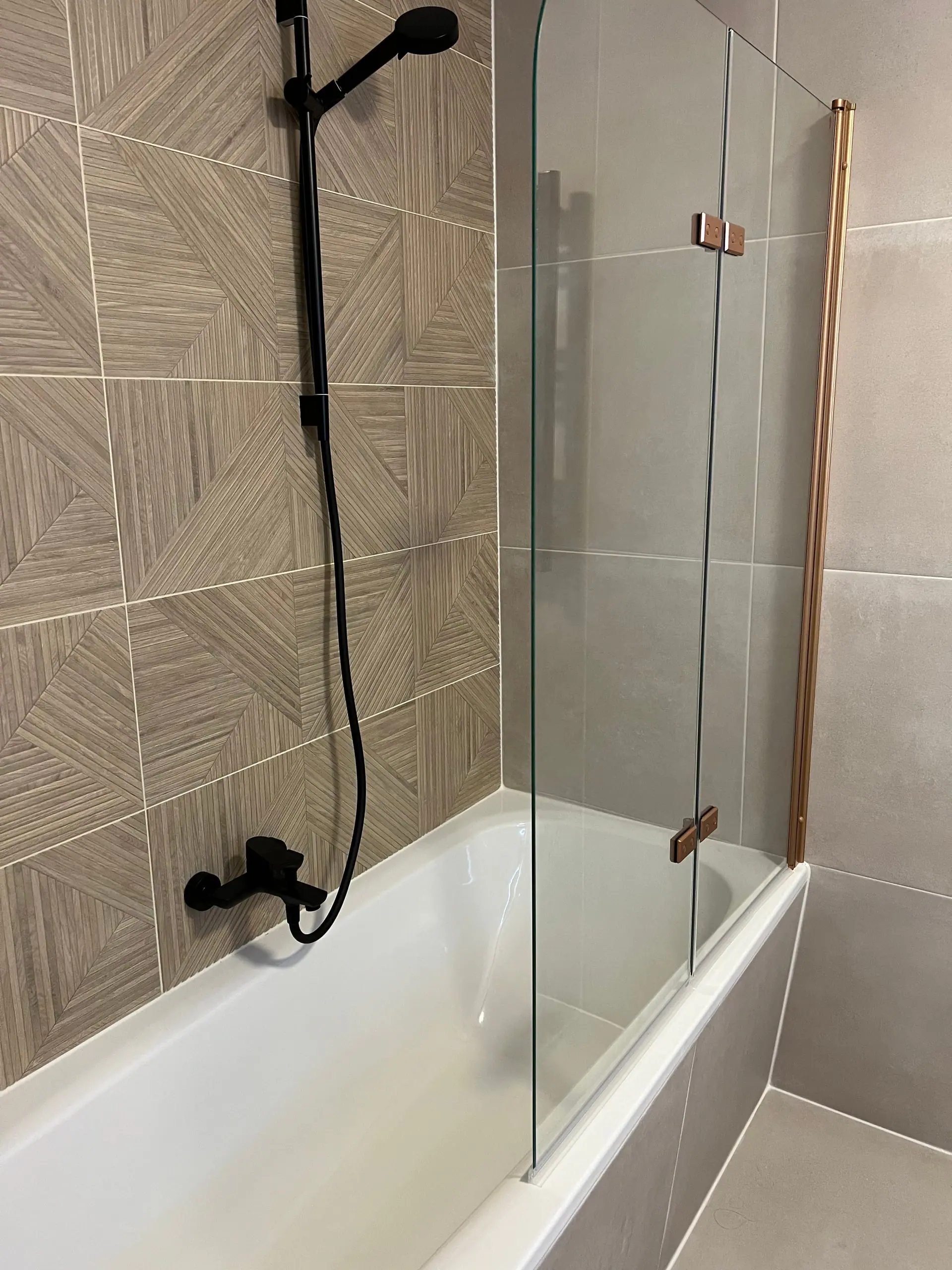 Het ligbad met koperen rek en glazen wand