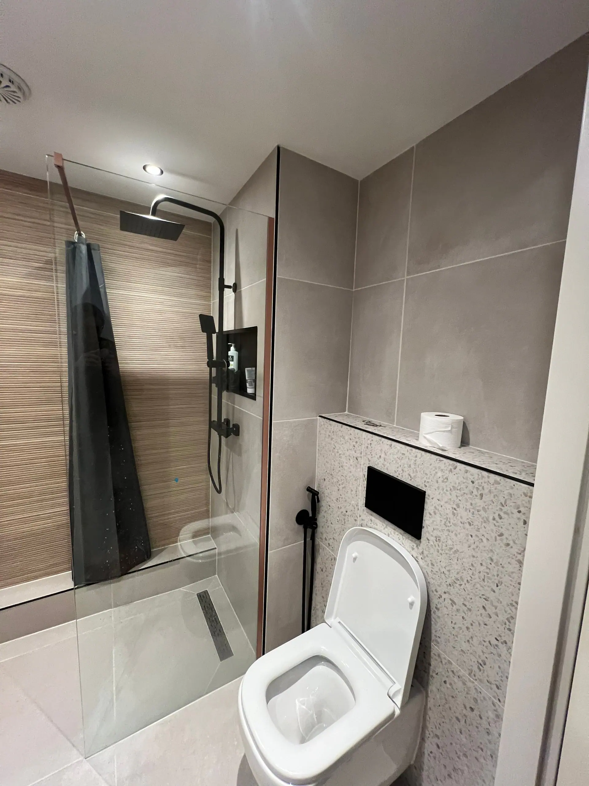 De tweede badkamer: toilet met terrazzo wand en spiegel